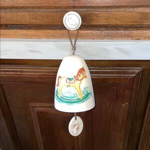 Artist-signed pottery bell w/rocking horse design